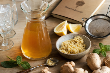 Recette du jus de gingembre : carafe de jus ambré, gingembre frais, citron, menthe