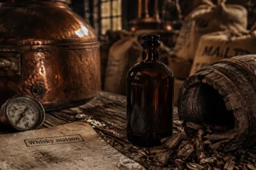 Whisky maison : bouteille, cuve en cuivre et copeaux de chêne